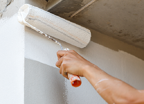 Un tecnico sta applicando delle vernici speciali per l'edilizia su un muro